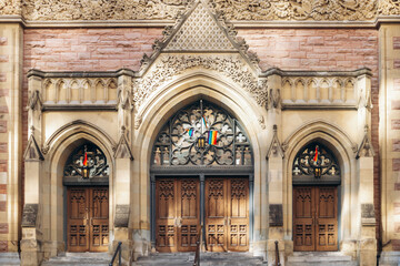 Montreal, Canada - August 12, 2025: Ornate church entrance with pride flags on Sainte-Catherine Street