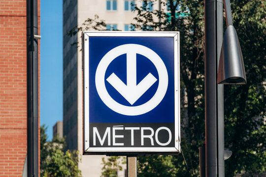 Montreal, Canada &ndash; August 12, 2025: Metro sign with a blue background and downward arrow in downtown Montreal.