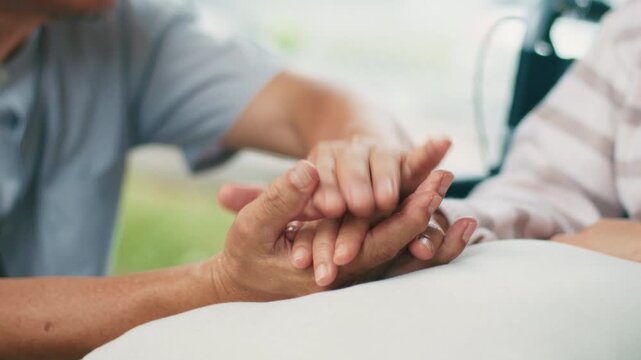 Close up of Asian Senior Elderly man holding Senior woman hand his wife taking care, give support empathy in park. Mental health, Relief and Trustworthy. Retirement life concept.