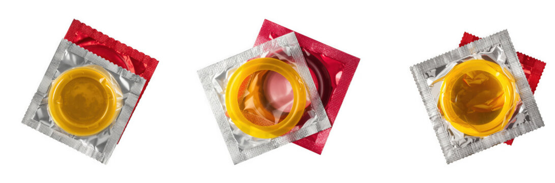 Three individually wrapped yellow condoms in foil packaging on a transparent background isolated on transparent background