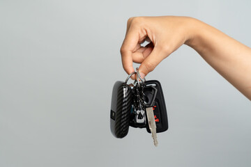 Hand Holding A Set Of Modern Car Keys On A Gray Background Studio Shot