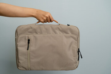 Hand Holding A Textured Laptop Bag Against A Plain Background With Studio Lighting