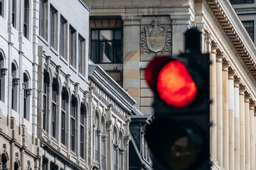 Downtown historic building facade with arched windows and red traffic light in foreground