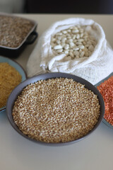 Bowls and bags full of various healthy grains and legumes. Selective focus.