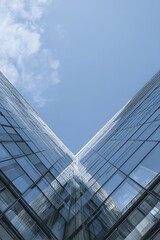 Modern architecture featuring a glass facade reflecting the blue sky above it