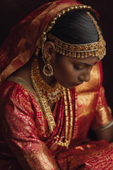Portrait of an Indian bride in traditional wedding attire, adorned with intricate jewelry, saree draping and warm soft light. Elegant, cultural and detailed bridal imagery.
