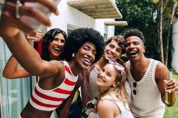 Friends take a sunny selfie at a casual outdoor party