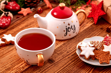 Tea cup, cookies and Christmas ornnaments on wooden table