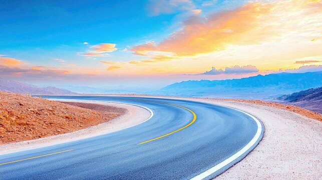 A winding asphalt road curves through a desert landscape under a vibrant sunset sky with colorful clouds and distant mountains. - Powered by Adobe