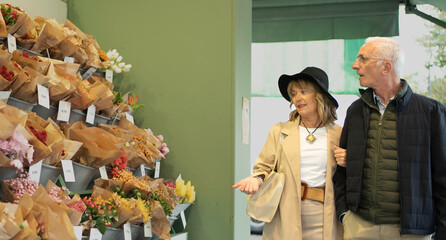 Mature couple shopping for bouquets at an outdoor flower shop