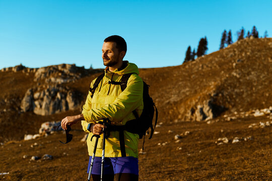 Man enjoying a peaceful moment while hiking in the mountains during sunset near rocky terrain