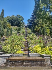 Beautiful view from the botanical garden with fountain, flowers, and trees on Insel Mainau at the Bodensee in Germany with sunny weather and blue sky 