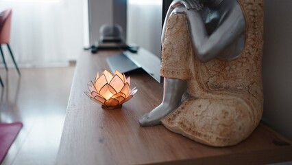 Lotus flower lamp illuminating a seated spiritual statue in a serene home interior