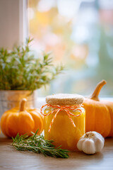 Fresh pumpkin and garlic nestled by a sunny window with rosemary in fall season