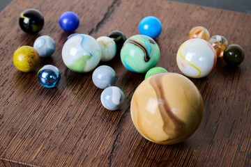 Indoor. Pretty colored marbles on a piece of wood