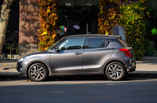 Yerevan Armenia 11.20.2025. A grey Suzuki hatchback car is parked on the side of the road