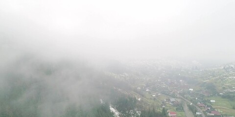 Thick fog in mountain, transparent clouds move under village