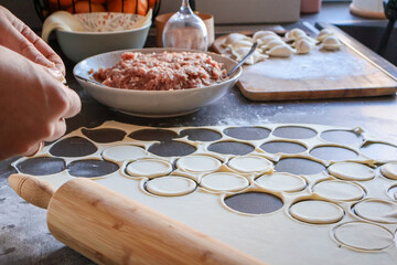 Close-up of family cooking together at home, showing two generations preparing traditional dumplings. Concept of togetherness, family bonding, realistic domestic life and learning new skills