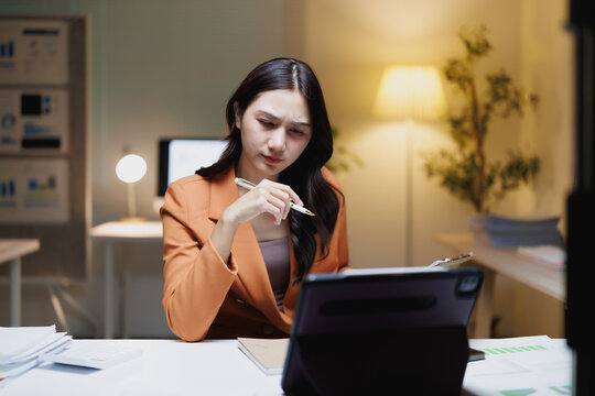 Asian businesswoman thinking working late on important data