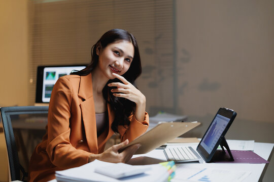 Asian businesswoman smiling while working with business data