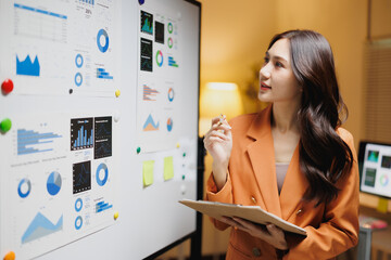 Asian businesswoman analyzing data and reviewing business presentation