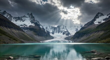 Mountain peaks, glacier and lake under dramatic sunlit clouds