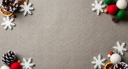 Christmas holiday background with festive decorations like snowflakes, pine cones, and dried oranges on a grey felt texture. Top view with copy space