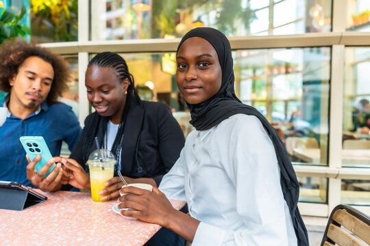 Diverse young adults enjoying coffee and sharing smartphone content in a cafe