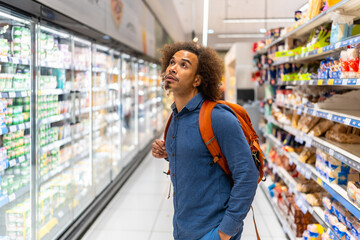 Man choosing products in supermarket aisle