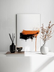 White wall with a large abstract painting hanging on it. the painting is made up of black and orange brushstrokes, creating a splatter-like effect.