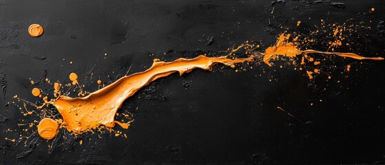 Close-up of an orange liquid splashing on a black background. the liquid appears to be in the shape of a wave or a splash, with droplets of the same orange color scattered across the surface.