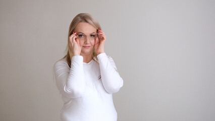 Young beautiful attractive woman adjusting glasses poor vision and looking side while sitting with...