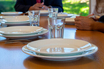 Dining table setting with clean plates and glasses