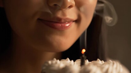 Close up of a woman blowing out a candle on a birthday cake creating a warm and celebratory atmosphere for a special occasion or milestone event