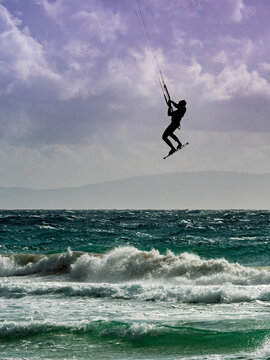 Kite surfer riding waves. Kiteboarding sport.