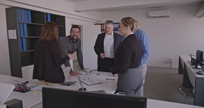 Business colleagues discuss ideas and strategies during a productive meeting in the office. Teamwork and collaboration are evident as they work together towards a shared goal.