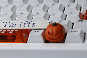 Tariffs concept on a mechanical keyboard with a small, spooky Halloween pumpkin, symbolizing global trade tensions, economic policy, and digital commerce