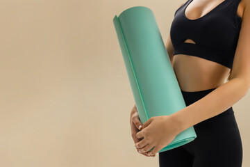 Close up of woman holding yoga mat, fitness gear, yoga equipment for training, pilates workout, gym essentials, healthy lifestyle and active routine on beige background.