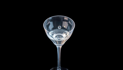 A single glass cup with a rising bubble, floating in the air, on a black background. Wallpaper, space for text, copy space, new year theme.