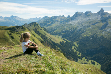 girl sitting on a high mountain with breathtaking view 