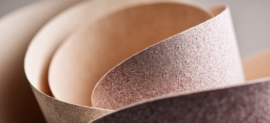 Curled textured paper layers in earth tones, soft light, close-up
