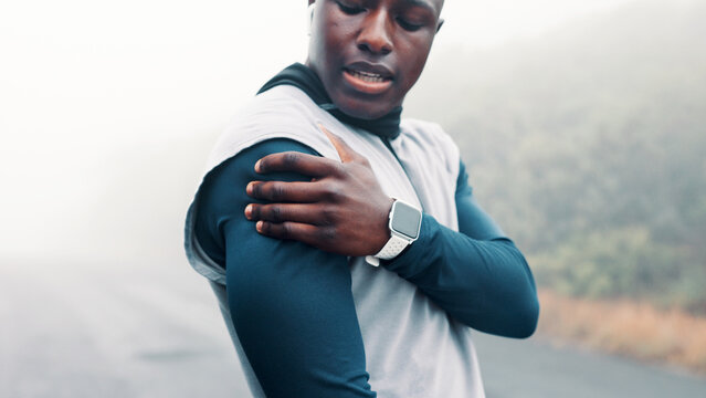 Outdoor, shoulder pain and black man with fitness, tension and accident with burnout or training in fog. African person, nature mist and runner with exercise, injury or athlete with muscle strain
