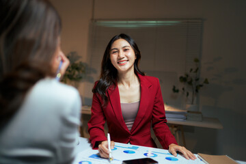Asian businesswoman smiling during data analysis meeting