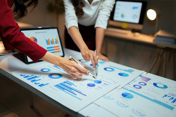 Businesswomen analyzing financial data with charts and graphs