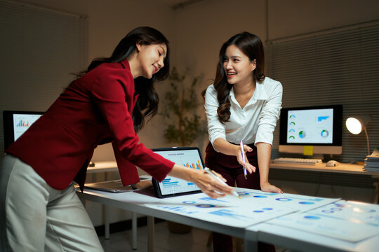 Businesswomen collaborating on business reports and data analysis - Powered by Adobe