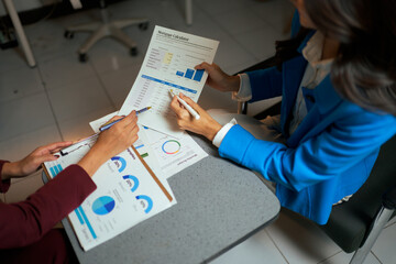 Businesswomen analyzing financial charts and data in office meeting