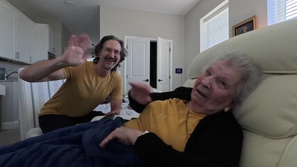 An elderly woman enjoys a heartfelt conversation with her son during his visit at the nursing home, capturing their close bond.