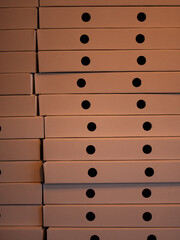 Stacked pizza boxes forming a geometric pattern with repeating circular cutouts, creating a clean minimalistic background ideal for food delivery concepts