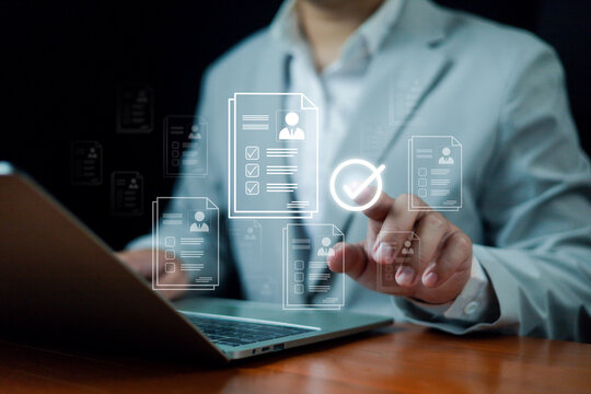 A business professional using a laptop, touching digital documents with a checkmark icon represents online document approval, workflow management, data verification, modern digital business processes.