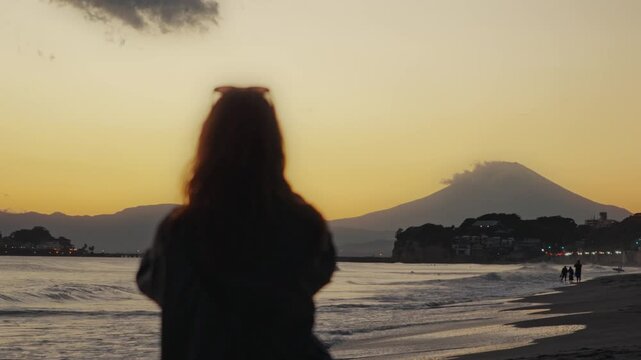 Woman watching a golden sunset over mount fuji